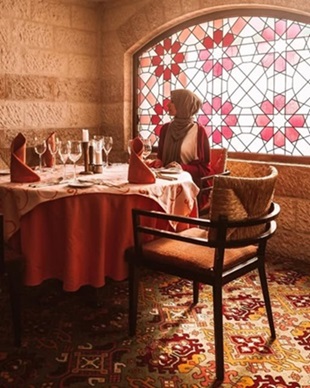A lady sitting by a dining table in 1001 Nights luxury Middle Eastern restaurant
